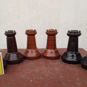 Peut inclure: Six pièces d'échecs en bois, deux brunes et quatre noires, disposées en rangée sur une surface en bois. Les pièces sont toutes en forme de tour.