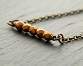 Fijne minimalistische ketting met facetten en matte kralen in brons