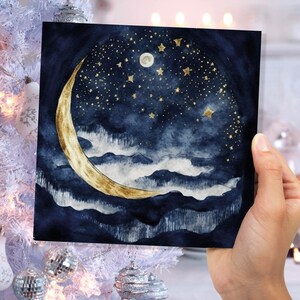 May include: A watercolour painting of a crescent moon with gold accents against a dark blue night sky with white clouds and gold stars.