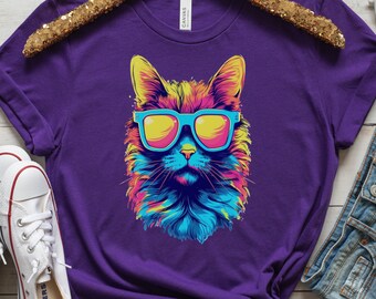 May include: Purple t-shirt featuring a colourful graphic of a cat wearing sunglasses.