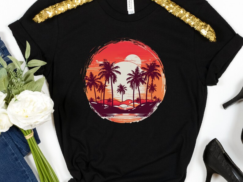 May include: Black t-shirt with a graphic of a sunset over palm trees in a circle. The graphic is in shades of red, orange, and yellow.