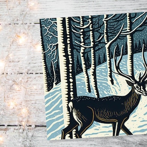 Carte de cerf linogravure hiver forêt enneigée Illustration bleu blanc noir paysage neige scène salutations pour la famille amis Noël 2025 Merci