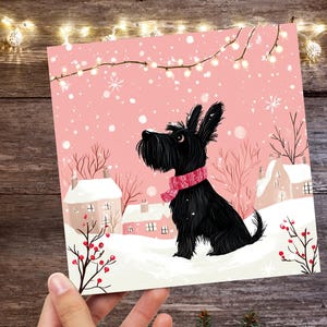 Biglietto di auguri di Natale con cane Scottie, simpatico Scottish Terrier nero e rosa, scena innevata, luci festive, neve invernale per gli amanti dei cani, famiglia, amici