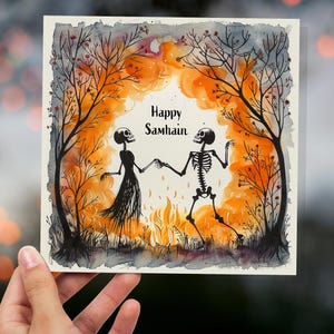 Tarjeta de feliz Samhain con esqueletos bailando junto a la hoguera de los árboles otoñales. Tarjetas de felicitación paganas únicas y alternativas de Halloween para fiestas familiares y amigos.