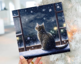 Katzen-Weihnachtskarte, süßes Kätzchen, das Schneefall beobachtet, getigertes verschneites Fenster, Winternachtszene, fallende, skurrile Grüße, Familie, Freunde, Weihnachten 2023