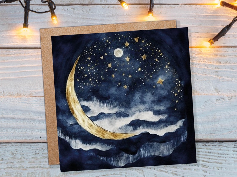 May include: A greeting card featuring a watercolour illustration of a crescent moon and stars against a dark blue background. The moon is gold and the stars are gold with a white centre. The background is a dark blue with white clouds.