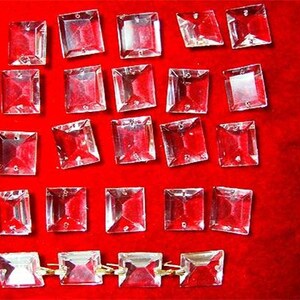 May include: A collection of clear glass square crystals, some are arranged in a row with gold connectors.