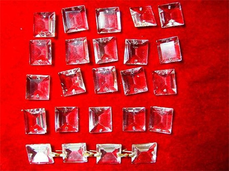 May include: A collection of clear glass square crystals, some are arranged in a row with gold connectors.