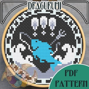 May include: A cross-stitch pattern in a wooden hoop featuring a blue dinosaur-like creature with a trident. The design includes white waves, gray accents, and the text "DRAGURUMI" and "PDF PATTERN".