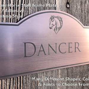 May include: Custom horse stall name plate with a brushed metal finish. The plate features a horse head silhouette and the name "DANCER" in a black font. The plate is mounted on a wooden surface.