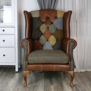 May include: A brown leather wingback armchair with a patchwork design featuring various shades of green, brown, and gray tweed fabric. The chair has a tufted back and a wooden frame with turned legs.