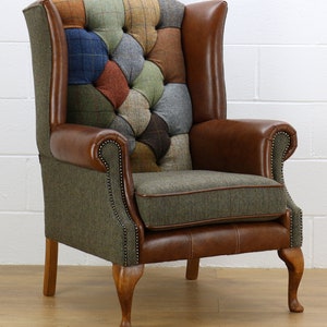 May include: A brown leather wingback armchair with a patchwork tweed fabric seat and back. The chair has a tufted design and wooden legs.