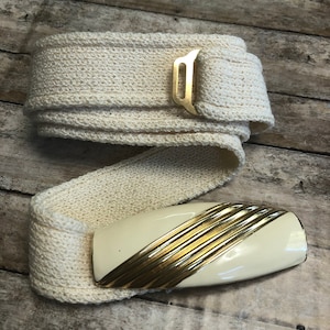 Vintage St. John ladies belt buckle with knitted belt.Cream enamel with gold strips