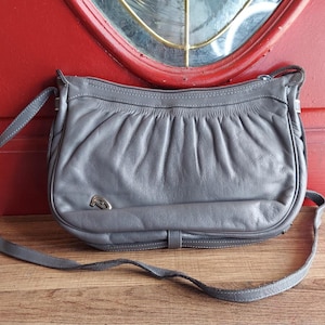 Bolso bandolera tipo cartera tipo mensajero de piel gris de Etienne Aigner.