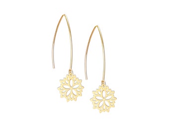 Op de afbeelding: Een paar gouden oorhangers met een delicaat bloemenmotief. De oorhangers zijn gemaakt van dun draad en hebben een lange, slanke val.