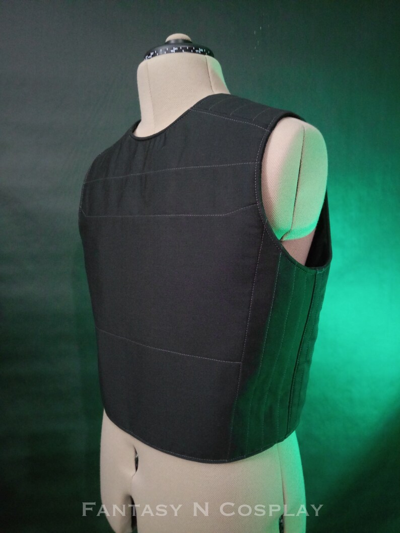 May include: Black quilted vest with a straight neckline and sleeveless design. The vest has a fitted silhouette and is made of a soft, comfortable fabric.