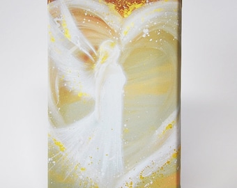 May include: A white angel with wings spread wide, painted on a canvas with a heart shape formed by the wings. The background is a soft yellow with gold accents.