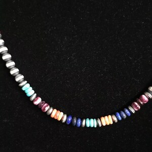 May include: A colorful beaded necklace with a variety of stones, including turquoise, lapis lazuli, and pink.