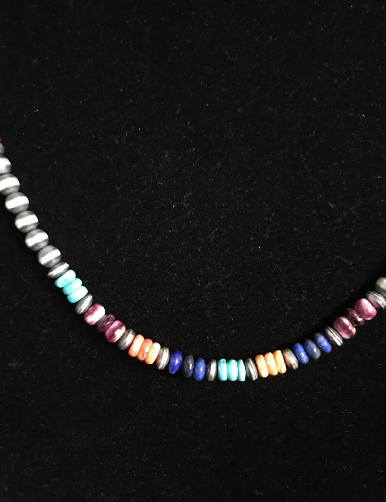 May include: A colorful beaded necklace with a variety of stones, including turquoise, lapis lazuli, and pink.