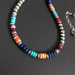 May include: A multi-colored beaded necklace with turquoise, lapis lazuli, coral, and silver beads.