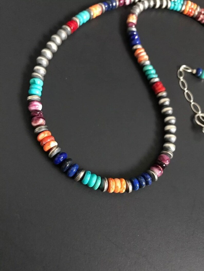 May include: A multi-colored beaded necklace with turquoise, lapis lazuli, coral, and silver beads.