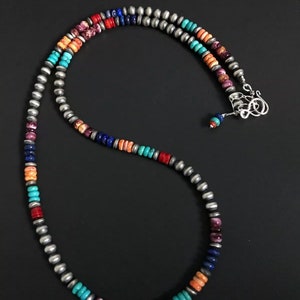 May include: A multi-colored beaded necklace with silver beads. The necklace features turquoise, coral, lapis lazuli, and purple stones.