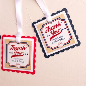 May include: Two red and blue thank you tags with scalloped edges and white ribbon. The tags have a vintage baseball theme and say "Thank You" with the text "I hope you had a ball" and a baseball graphic.