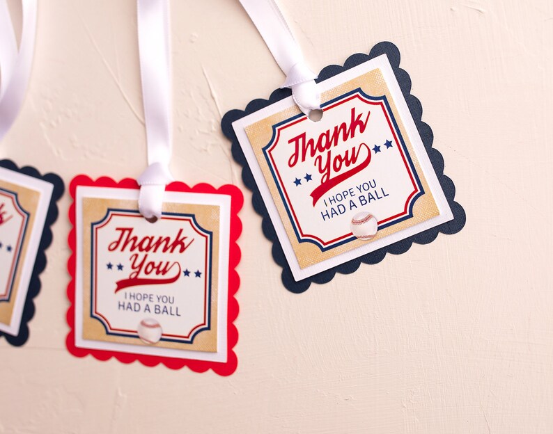May include: Two red and blue thank you tags with scalloped edges and white ribbon. The tags have a vintage baseball theme and say "Thank You" with the text "I hope you had a ball" and a baseball graphic.