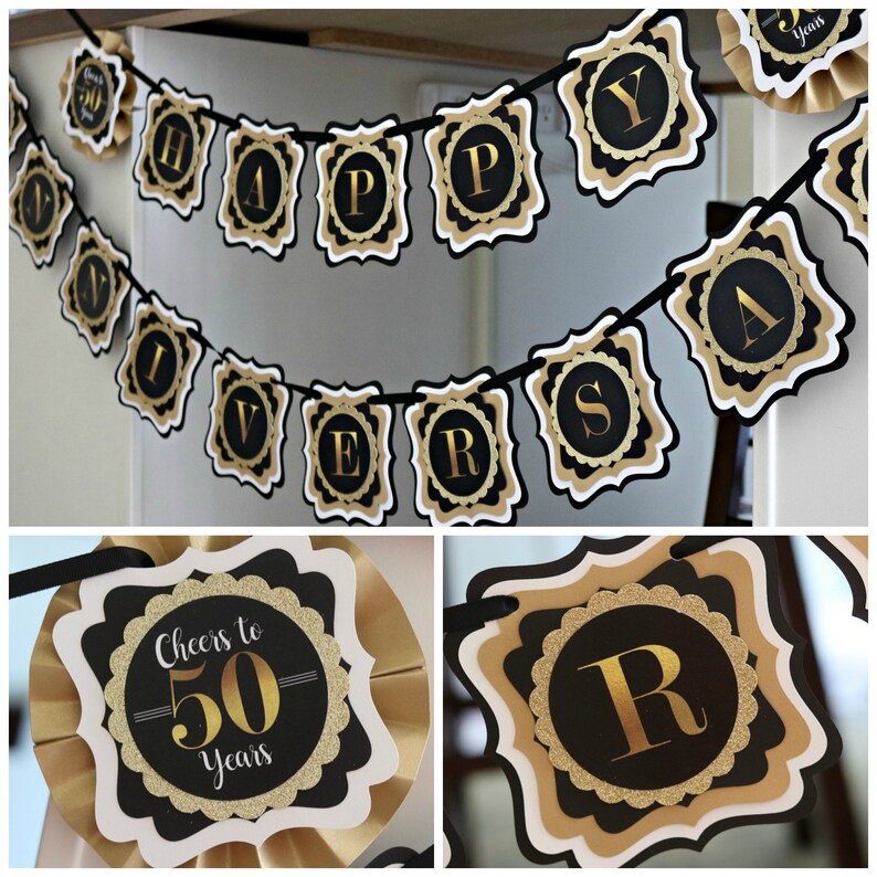 May include: Black and gold banner with the words "Happy Anniversary" and a separate black and gold sign that says "Cheers to 50 Years".
