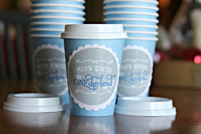 May include: Blue and white paper cups with a scalloped edge and a gray circle with the text "Milo's Winter Wonderland" in blue and white lettering.