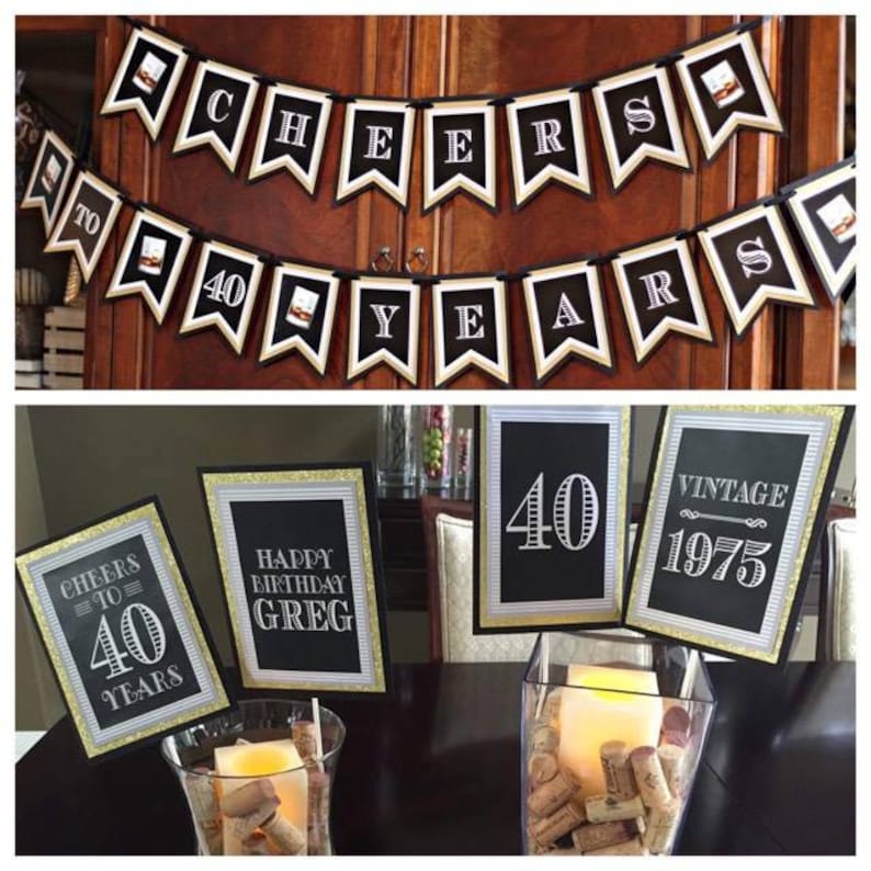 May include: Black and gold 40th birthday party decorations with a vintage theme. The decorations include a banner that says "Cheers to 40 Years", table signs that say "Cheers to 40", "Happy Birthday Greg", "40", and "Vintage 1975", and a vase filled with wine corks.