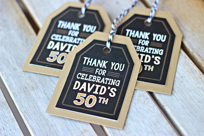 May include: Three brown paper gift tags with black and white text that says "Thank you for celebrating David's 50th".