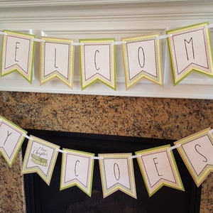 May include: A green and yellow banner with the words "Welcome Baby Coates" and a small book icon with the words "New Chapters" on it.