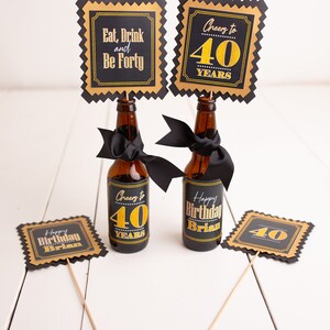 May include: Four black and gold party decorations with the text "Eat, Drink and Be Forty", "Cheers to 40 Years", "Happy Birthday Brian" and "40".