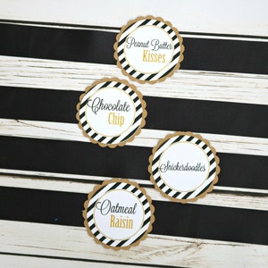 May include: Four round, scalloped-edge, brown paper labels with black and white striped backgrounds. The labels have gold text that reads "Peanut Butter Kisses", "Chocolate Chip", "Snickerdoodles", and "Oatmeal Raisin".