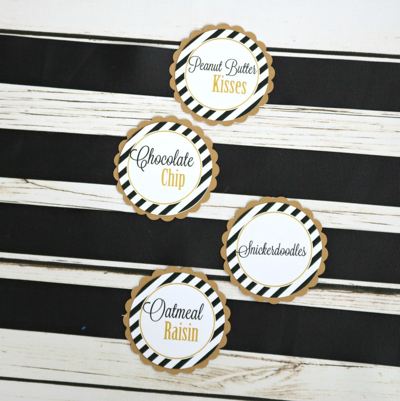 May include: Four round, scalloped-edge, brown paper labels with black and white striped backgrounds. The labels have gold text that reads "Peanut Butter Kisses", "Chocolate Chip", "Snickerdoodles", and "Oatmeal Raisin".