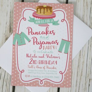 May include: Pink invitation with white polka dots, featuring a stack of pancakes, a pair of pajamas, and the text "Join us for a Pancakes and Pajamas Party to celebrate Natalie and Victoria's 2nd Birthday. Scott's House of Pancakes Sunday December 9th @ 10:00am 31893 Cast Iron Cove, Bulverde TX RSVP to Melissa at (210) 831-7660"