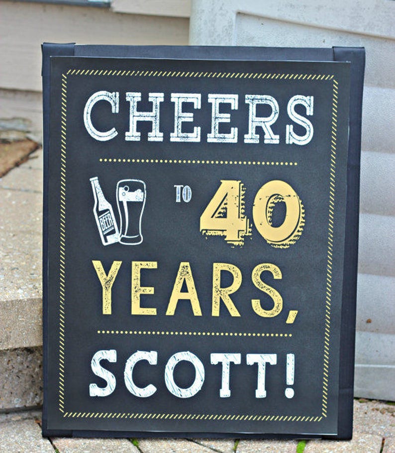 May include: Black chalkboard sign with gold lettering that reads "Cheers to 40 Years, Scott!" with a beer bottle and glass illustration.