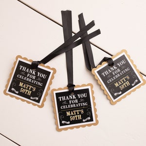 May include: Three black and gold favor tags with scalloped edges and black ribbon. The tags say "Thank you for celebrating Matt's 50th".