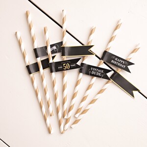 May include: Set of six gold and white striped paper straws with black flags. The flags have the text "Happy Birthday", "Vintage Dude", and "Aged 50 Years".