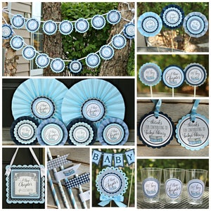 May include: A new chapter baby shower party decorations in blue and gray with a book theme. The decorations include a banner, cupcake toppers, favor tags, and centerpieces. The text on the decorations says "A New Chapter" and "Baby Boy".