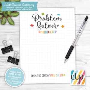 May include: White notepad with a grid pattern, a black pen, and two binder clips. The notepad has the words "Problem Solver" and "#MATHTEACHER" in colorful text. The text "FROM THE DESK OF MRS. GOLDMAN" is also visible.