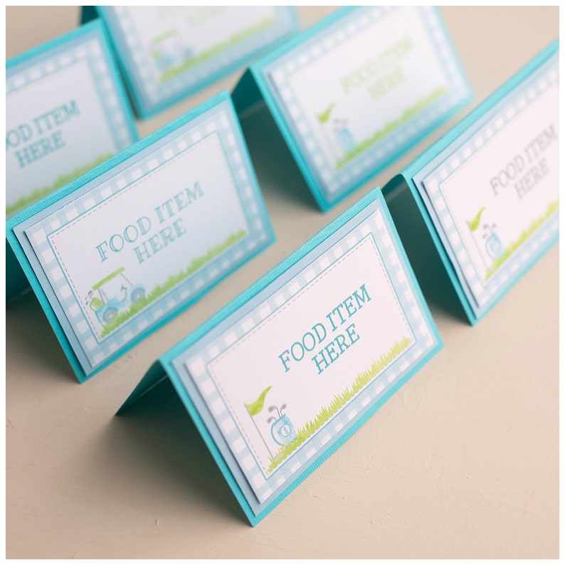 May include: Set of five blue and white food labels with a golf cart and golf clubs design. Each label says "Food Item Here".