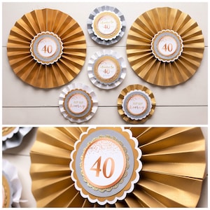 Puede incluir: Abanicos de papel dorados y plateados con el n&uacute;mero 40 impreso en ellos. Los abanicos est&aacute;n decorados con purpurina dorada rosa y el texto "Cheers to 40" y "Sip Sip Hooray".