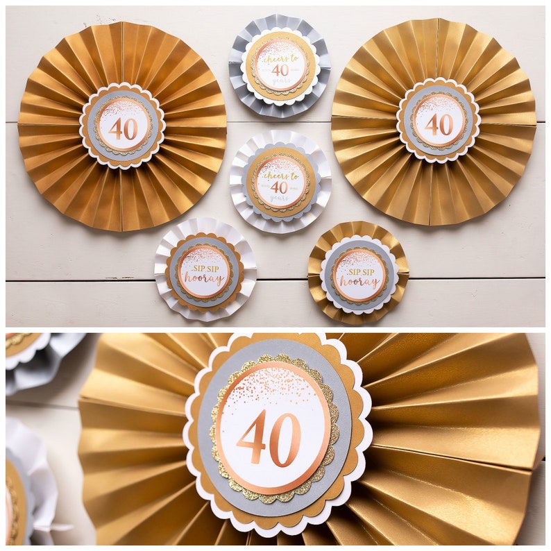 Puede incluir: Abanicos de papel dorados y plateados con el n&uacute;mero 40 impreso en ellos. Los abanicos est&aacute;n decorados con purpurina dorada rosa y el texto "Cheers to 40" y "Sip Sip Hooray".