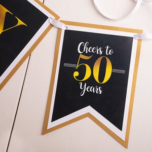 Puede incluir: Pancarta negra y dorada con el texto "Cheers to 50 Years".