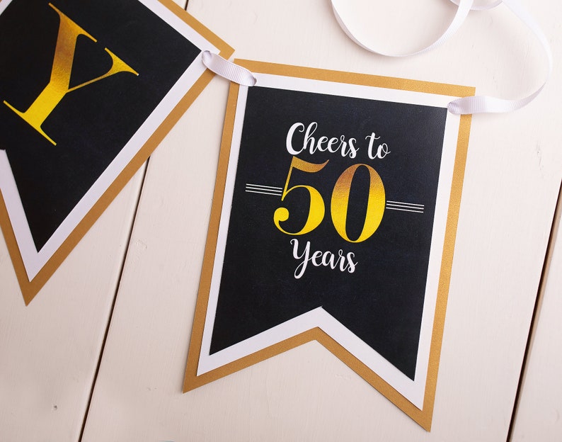 Puede incluir: Pancarta negra y dorada con el texto "Cheers to 50 Years".