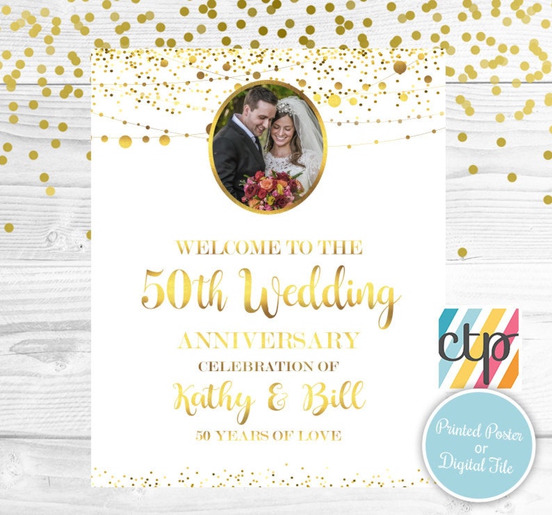 May include: A white poster with gold confetti and a photo of a couple in the center. The text reads "Welcome to the 50th Wedding Anniversary Celebration of Kathy & Bill 50 Years of Love".