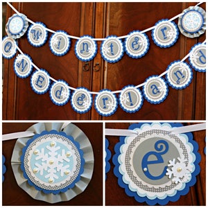 May include: A winter wonderland themed banner with blue and gray scalloped circles. Each circle has a white snowflake and a letter spelling out "Winter Wonderland".