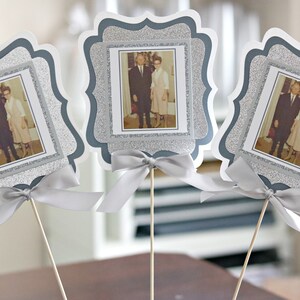 May include: Three silver glitter picture frames with white borders and a silver ribbon bow. Each frame holds a black and white photo of a couple.